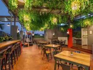 a restaurant with wooden tables and chairs and plants at Z Stays, Silkboard in Bangalore