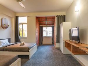a bedroom with a bed and a tv in it at Z Stays, Silkboard in Bangalore