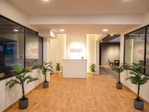 a lobby with palm trees and a sign that reads loop at Z Stays, Silkboard in Bangalore