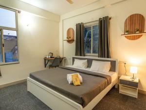 a bedroom with a bed with a yellow stuffed animal on it at Z Stays, Silkboard in Bangalore +23 photos