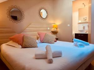a bedroom with a bed with two towels on it at La Carpe d'Or in Fontainebleau