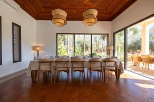 a dining room with a long table and chairs at Villa Yliane in Marrakesh +47 photos