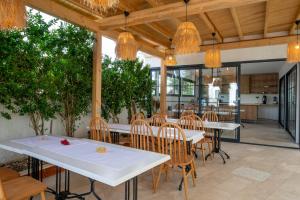 a restaurant with white tables and chairs and chandeliers at Orion hotel in Bodrum City