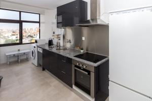 a kitchen with black cabinets and a sink at Guest H4U Povoa Vacation City center in Póvoa de Varzim