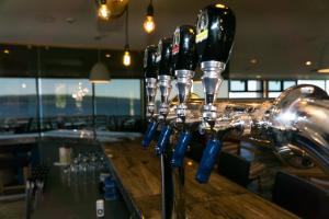 a row of wine bottles lined up on a bar at Riotel Perce in Perce
