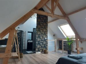 a room with a bed and a wooden floor at Gîte coup de cœur in Pluvigner