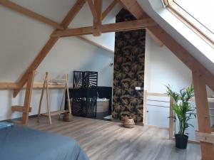 a attic room with a bed and a wooden floor at Gîte coup de cœur in Pluvigner
