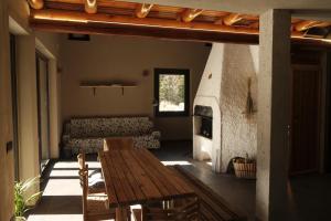 a living room with a wooden table and a fireplace at Rèfol Lodge Val di Ledro in Pur