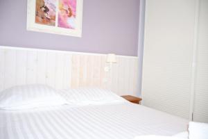 a bedroom with a white bed and a picture on the wall at Swing Moliets - T2 bis - Golf - 3 Piscines - Plage in Moliets-et-Maa +14 photos