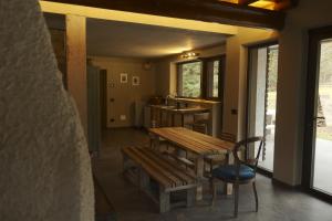 a porch with a wooden table and benches in a room at Rèfol Lodge Val di Ledro in Pur +20 photos