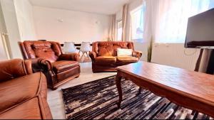 a living room with two leather chairs and a coffee table at Stadtmitte Apartment im historischen Viertel -100qm Wohnfläche & 30qm Dachterrasse in Schwäbisch Gmünd