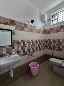 a bathroom with a sink and a toilet and a mirror at Hotel Rhythms Residency in Chennai