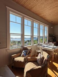 a living room with a couch and a table and windows at Trinity's Oceanview Gem 2BR St Paul's Schoolhouse in Trinity