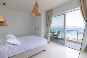 a bedroom with a bed and a view of the ocean at Euphoria Mare in Néa Palátia