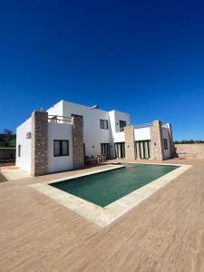 a villa with a swimming pool in front of a building at Villa Luxury Spacious Moroccan ,Private Pool in Essaouira