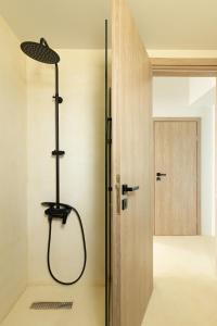 a shower in a bathroom next to a door at Euphoria Mare in Néa Palátia +67 photos