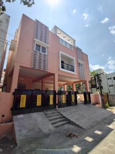a pink house with a gate in front of it at Hotel Rhythms Residency in Chennai