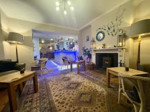 a living room with a table and a fireplace at Penryn House Hotel in Polperro