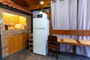 a kitchen with a refrigerator and a table and a window at Casa Fernandes by Mth in Ribeira Brava
