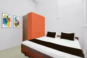 a bedroom with a large bed with two pillows at SPOT ON Milan Hotel in Hāthras