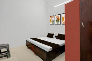 a bed in a room with a red wall at SPOT ON Milan Hotel in Hāthras