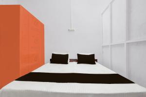 a bedroom with a bed with two pillows on it at SPOT ON Milan Hotel in Hāthras