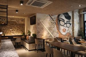 ein Restaurant mit einer Couch und Tischen und einem Wandgemälde in der Unterkunft ARVA Spa París in León