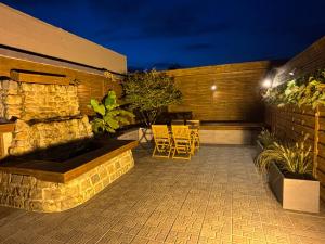 a patio with chairs and a stone wall at night at Taelia spa in Rosult