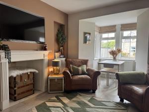 a living room with two chairs and a fireplace at Altonhill Cottage - room only in Nairn