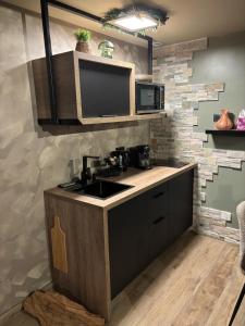 a kitchen with a sink and a microwave at Taelia spa in Rosult