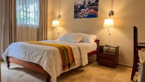 ein Schlafzimmer mit einem Bett, auf dem zwei Lampen stehen in der Unterkunft Hotel Israel - Lago Agrio in Nueva Loja