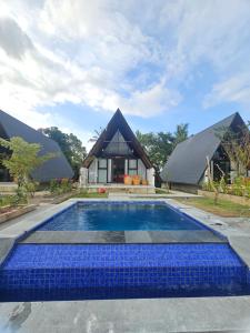 a house with a swimming pool in front of a house at Senaru Paradise in Senaru