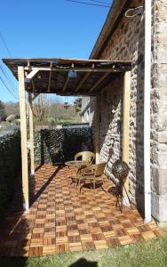 a wooden pergola with a table and chairs on a patio at Le Petit Montceaux in Le Val-Saint-Père