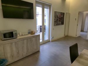 a living room with a microwave and a tv on the wall at Casa Bon in Marigliano +11 photos