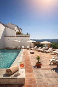 a villa with a swimming pool and lounge chairs at Avanel Boutique Apartments in Ronda