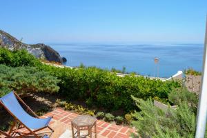 a patio with chairs and the ocean in the background at Maridea - Il Paradiso sulla Baia in Ponza