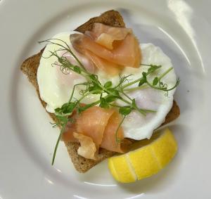 a plate of food with eggs and fish on toast at Penryn House Hotel in Polperro +1 photo