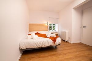 a white bedroom with a large bed with two pillows at Sarridal, Lar Atlántico in Cedeira