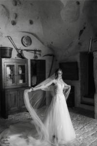 a woman in a wedding dress holding her veil at La Suite Nella Roccia in Matera