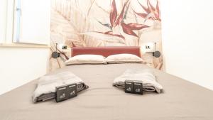 a bedroom with a bed with two pillows on it at DOMUS 1435 - Iconic Suites in Centro in Mantova