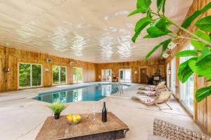 a swimming pool in a house with wooden walls at Indoor Pool Poconos Retreat with Arcade in Lake Ariel