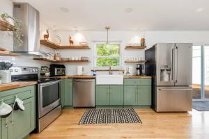 a kitchen with green cabinets and stainless steel appliances at Indoor Pool Poconos Retreat with Arcade in Lake Ariel