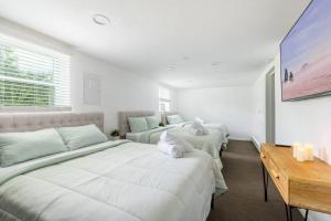 a white bedroom with two beds and a table at Indoor Pool Poconos Retreat with Arcade in Lake Ariel +55 photos