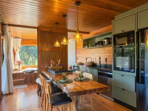 a kitchen with a wooden ceiling and a wooden table at Villa Vida Cabanas in São Joaquim