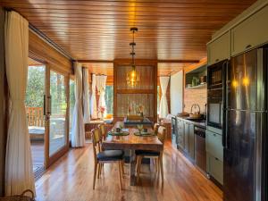 a kitchen with a wooden ceiling and a table with chairs at Villa Vida Cabanas in São Joaquim +24 photos