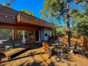 a deck with chairs and a bench and a table at Villa Vida Cabanas in São Joaquim
