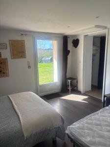 a bedroom with a bed and a large window at Chambre d'Hôtes Arla Goxoki in Amendeuix-Oneix