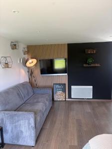 a living room with a couch and a flat screen tv at Chambre d'Hôtes Arla Goxoki in Amendeuix-Oneix