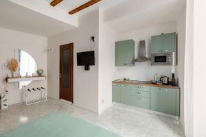 a kitchen with green cabinets in a white room at Lecco's heart! Centro Lecco - A due passi dal lago - Moderno e luminoso in Lecco