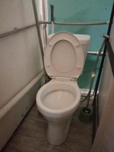 a bathroom with a toilet with the lid up at room with a mountain view in Zugdidi
